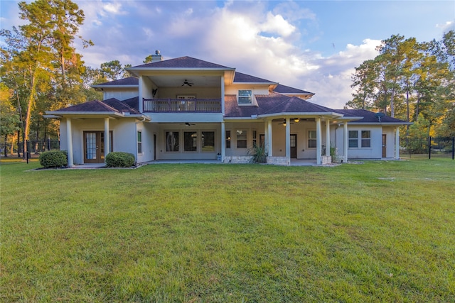 rear view of house featuring ceiling fan, a yard, and a patio