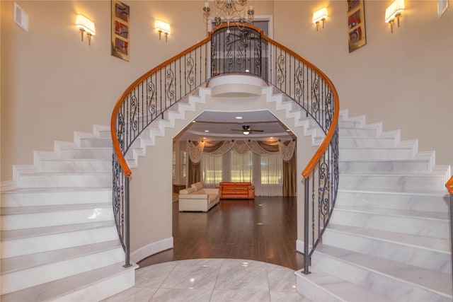 19523 Riverwalk Dr, Porter, TX 77365 - staircase featuring a high ceiling, a chandelier, ceiling fan, wood finished floors, and baseboards