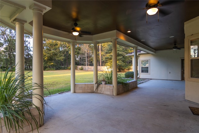 unfurnished sunroom with a wealth of natural light, ceiling fan, and ornate columns