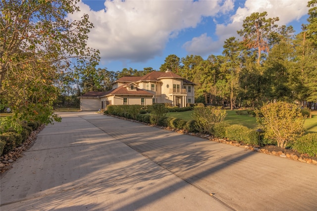 mediterranean / spanish house featuring a garage and a front lawn