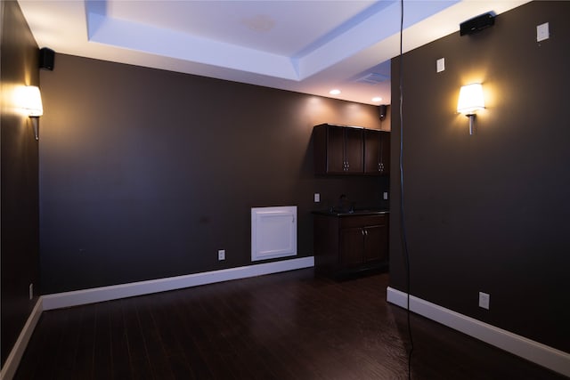 interior space featuring sink, a raised ceiling, and dark hardwood / wood-style flooring