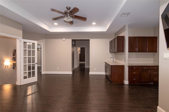 kitchen with dark brown cabinetry, a raised ceiling, and dark wood-type flooring