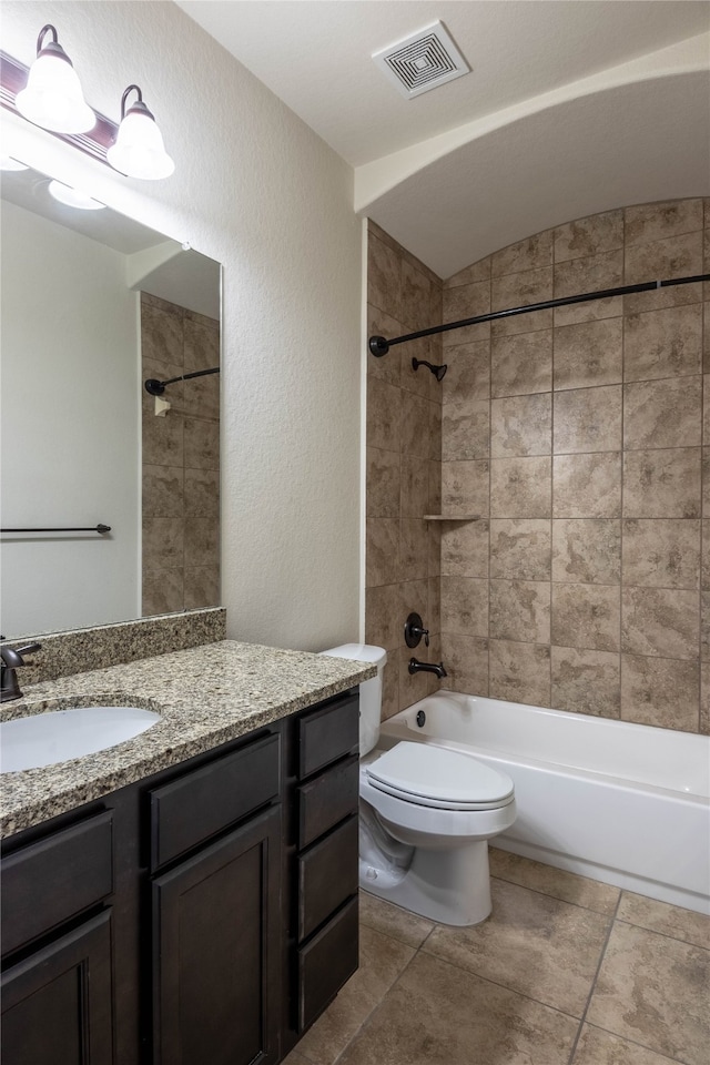 full bathroom featuring tiled shower / bath combo, vanity, and toilet