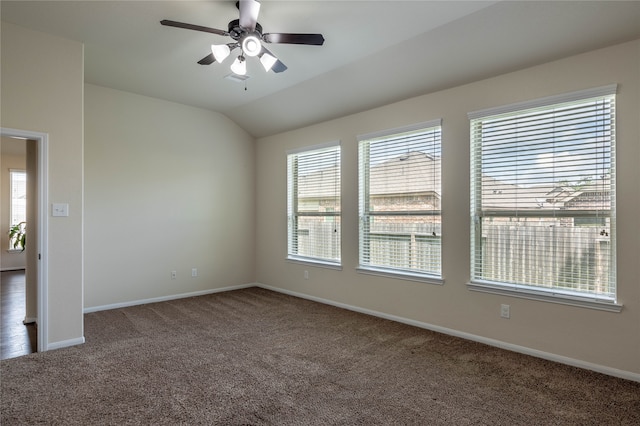 carpeted spare room featuring vaulted ceiling and ceiling fan