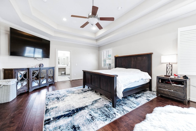 bedroom featuring connected bathroom, a tray ceiling, ceiling fan, and dark hardwood / wood-style floors