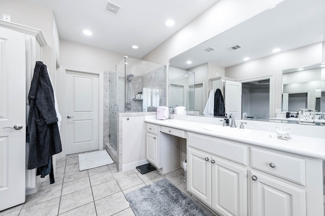 bathroom featuring tile patterned flooring, a shower with door, and vanity