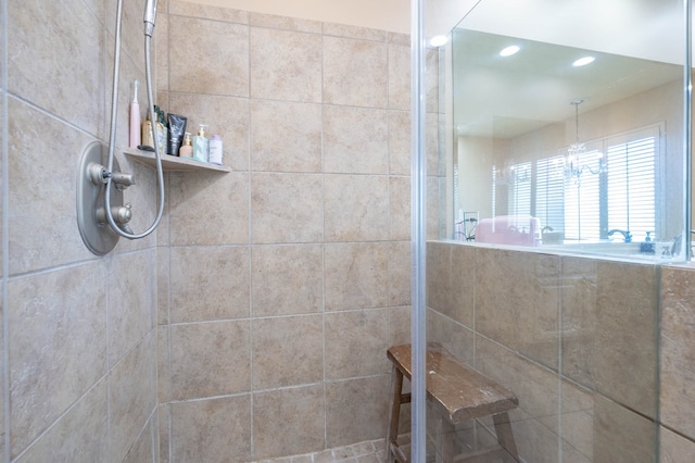 bathroom with a tile shower and an inviting chandelier