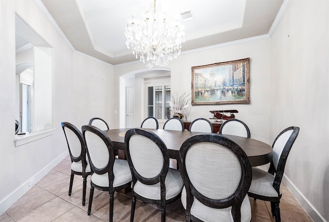 tiled dining room with an inviting chandelier, a tray ceiling, and crown molding