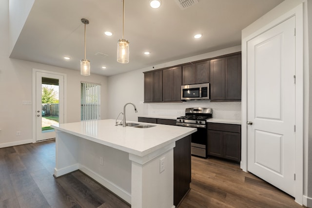 kitchen featuring dark brown cabinetry, hanging light fixtures, sink, stainless steel appliances, and dark hardwood / wood-style floors