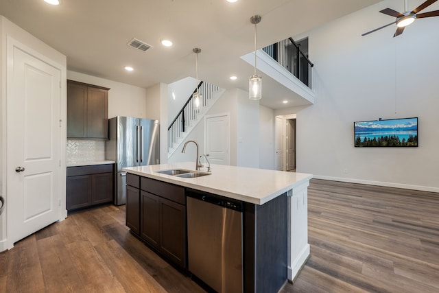 kitchen with sink, stainless steel appliances, hanging light fixtures, and dark hardwood / wood-style floors