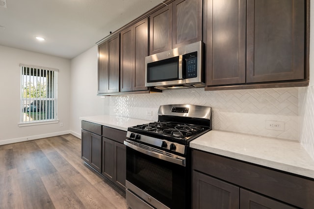 kitchen with decorative backsplash, light hardwood / wood-style floors, dark brown cabinets, and stainless steel appliances