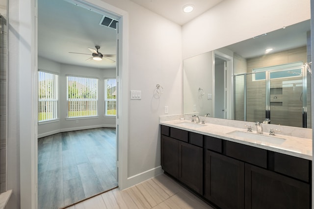 bathroom with ceiling fan, vanity, hardwood / wood-style floors, and a shower with door