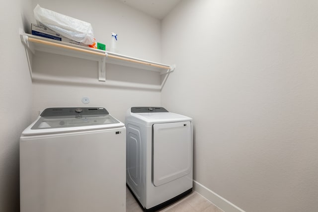 laundry room featuring light tile patterned floors and separate washer and dryer