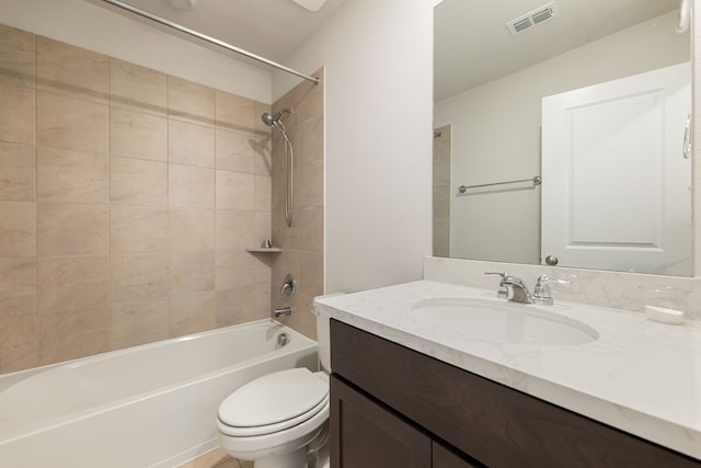 full bathroom featuring tiled shower / bath combo, vanity, and toilet