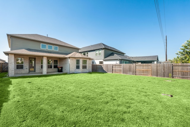 back of house with a lawn and a patio area