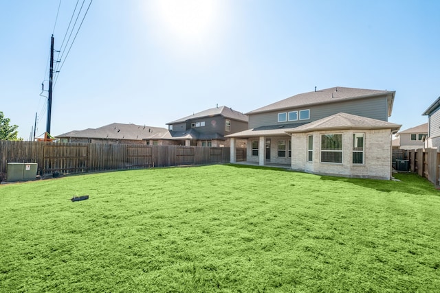 back of property featuring a yard and central air condition unit