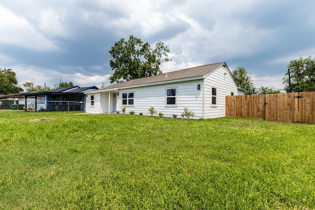 back of property with a sunroom and a lawn