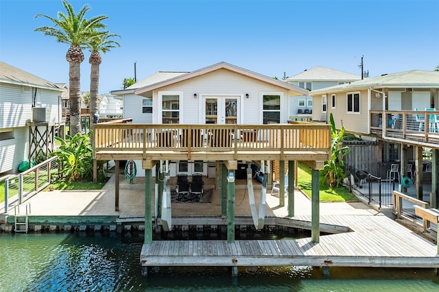 back of house featuring a deck with water view, a patio area, and central AC