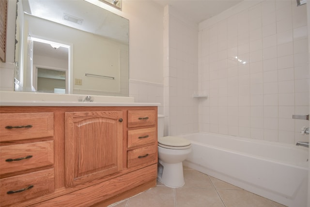 full bathroom with vanity, tiled shower / bath, toilet, and tile patterned flooring