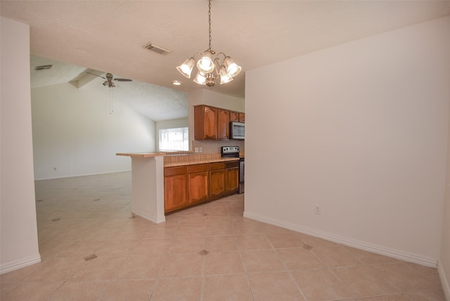 kitchen featuring a breakfast bar area, appliances with stainless steel finishes, a textured ceiling, vaulted ceiling with beams, and decorative light fixtures