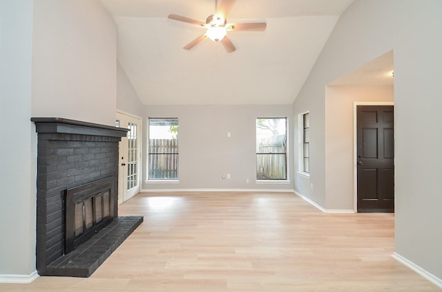 unfurnished living room featuring ceiling fan, vaulted ceiling, light hardwood / wood-style flooring, and a brick fireplace