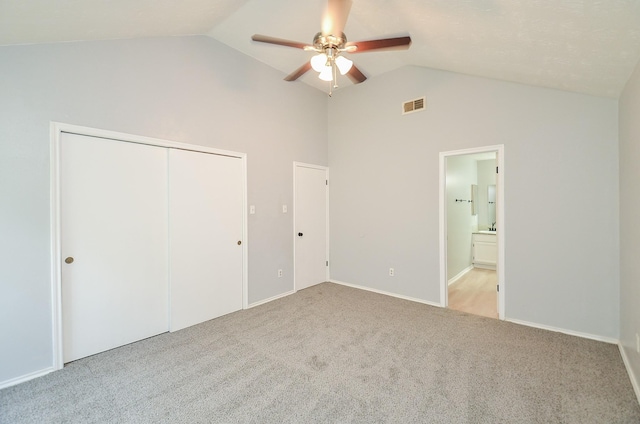 unfurnished bedroom with ceiling fan, a closet, ensuite bathroom, and light colored carpet