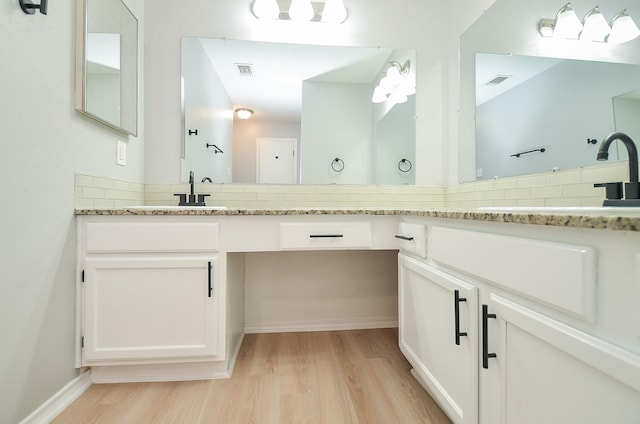 bathroom with decorative backsplash, vanity, and hardwood / wood-style flooring