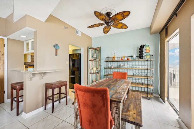 tiled dining area featuring ceiling fan and a textured ceiling