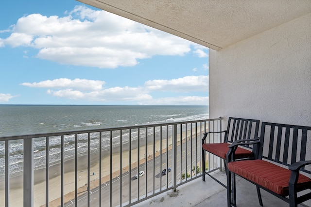 balcony with a water view and a beach view