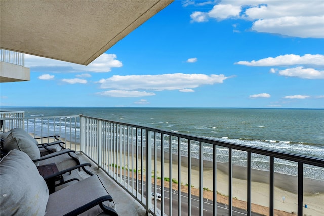 balcony featuring a water view and a view of the beach