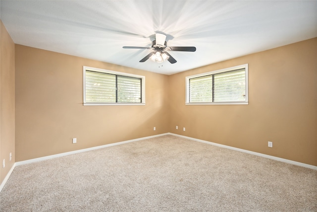 carpeted spare room with ceiling fan