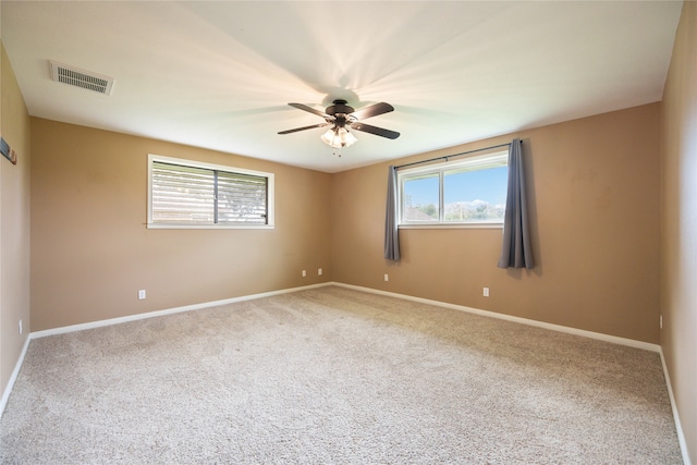 unfurnished room with carpet flooring, ceiling fan, and plenty of natural light