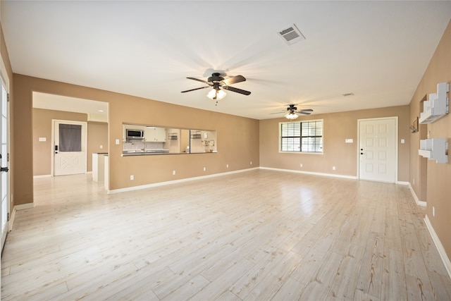 unfurnished living room featuring ceiling fan and light wood-type flooring