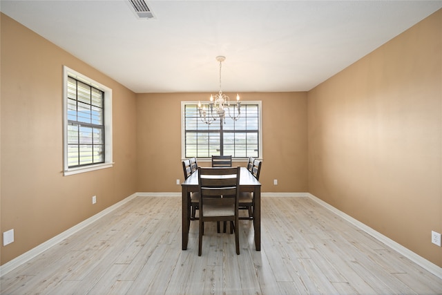 dining space with a notable chandelier and light hardwood / wood-style floors