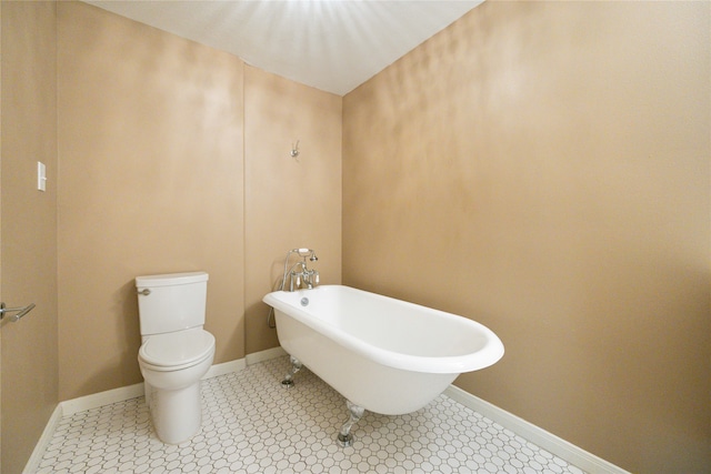 bathroom featuring tile patterned floors, a tub, and toilet