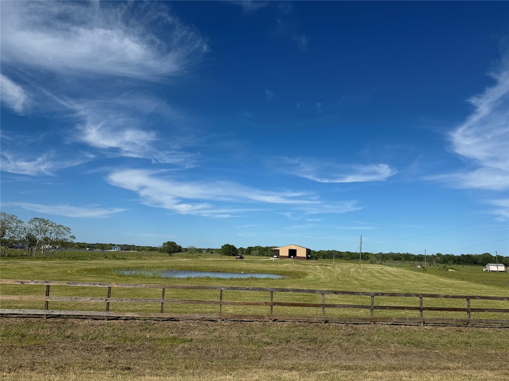 view of yard with a water view and a rural view