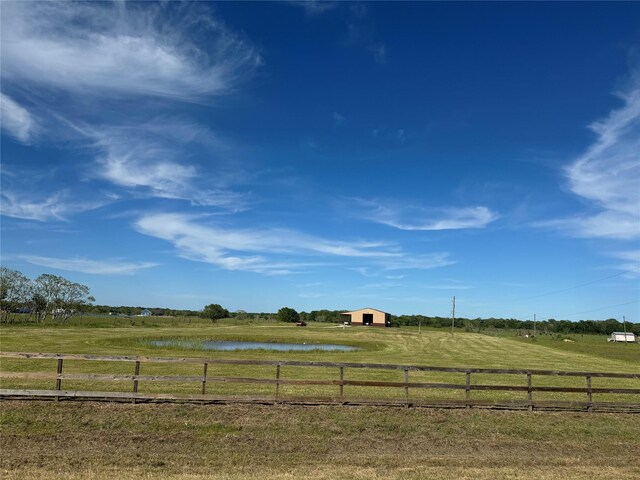 view of yard with a water view and a rural view