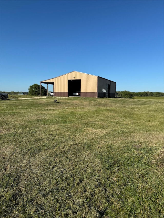 view of yard with an outdoor structure and a rural view