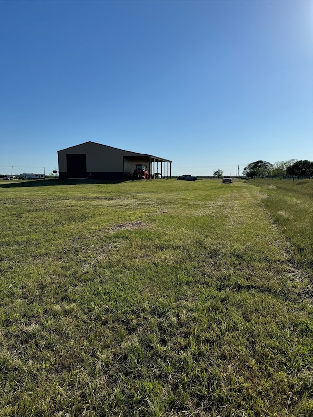 view of yard with an outbuilding and a rural view