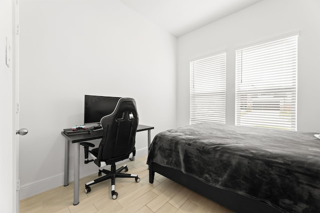 bedroom with lofted ceiling and light hardwood / wood-style floors