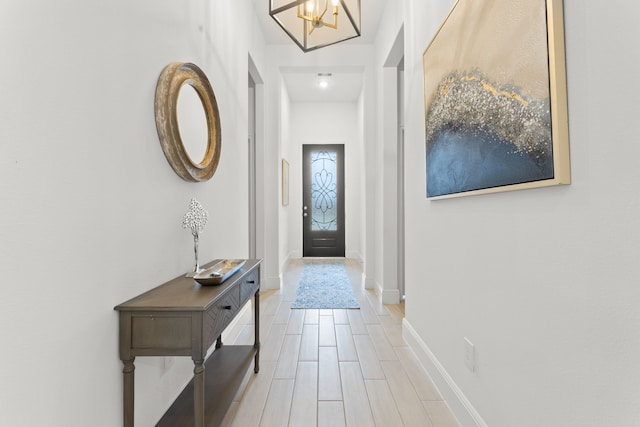 foyer with light wood-type flooring and an inviting chandelier