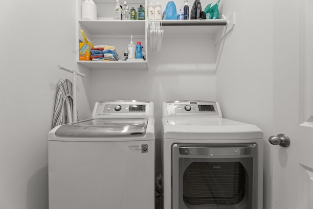 clothes washing area with washing machine and dryer