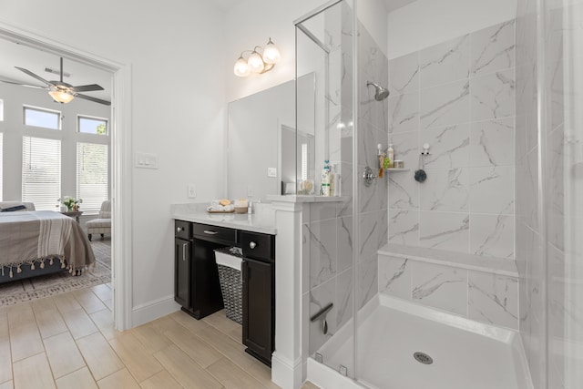 bathroom with a tile shower, ceiling fan, and vanity