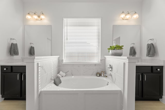 bathroom with tile patterned flooring, vanity, and a bathing tub