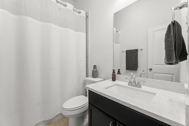 bathroom featuring tile patterned flooring, curtained shower, vanity, and toilet