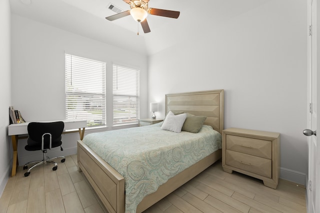 bedroom featuring ceiling fan, light hardwood / wood-style flooring, and lofted ceiling