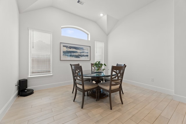 dining space with vaulted ceiling and light hardwood / wood-style flooring