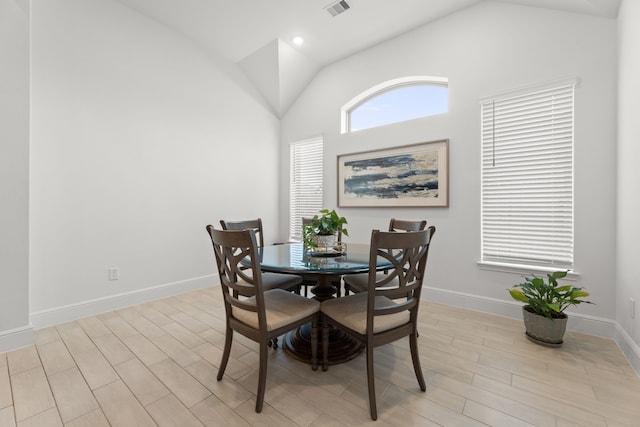 dining space with light hardwood / wood-style flooring and vaulted ceiling