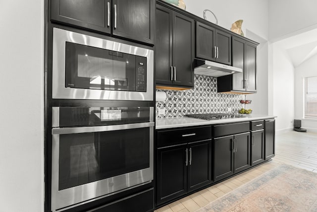 kitchen with stainless steel appliances, light hardwood / wood-style floors, and tasteful backsplash