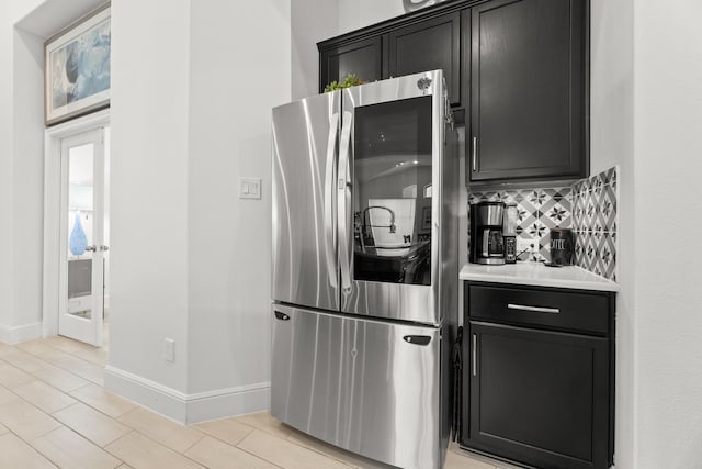 kitchen with stainless steel fridge and decorative backsplash